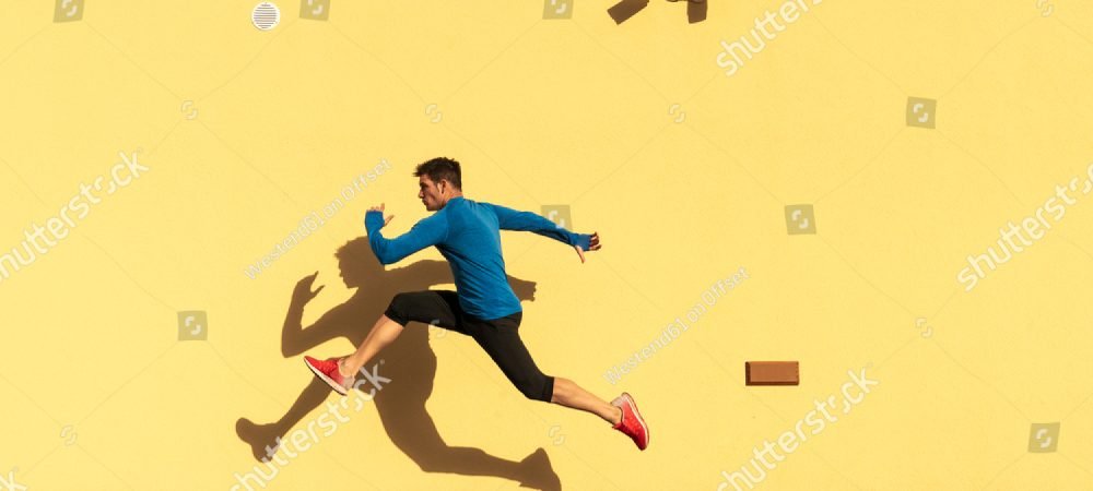 stock-photo-sportive-man-exercising-at-yellow-wall-with-cctv-camera-1895604094